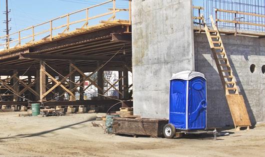 portable toilets lined up neatly, ready to serve job site workers